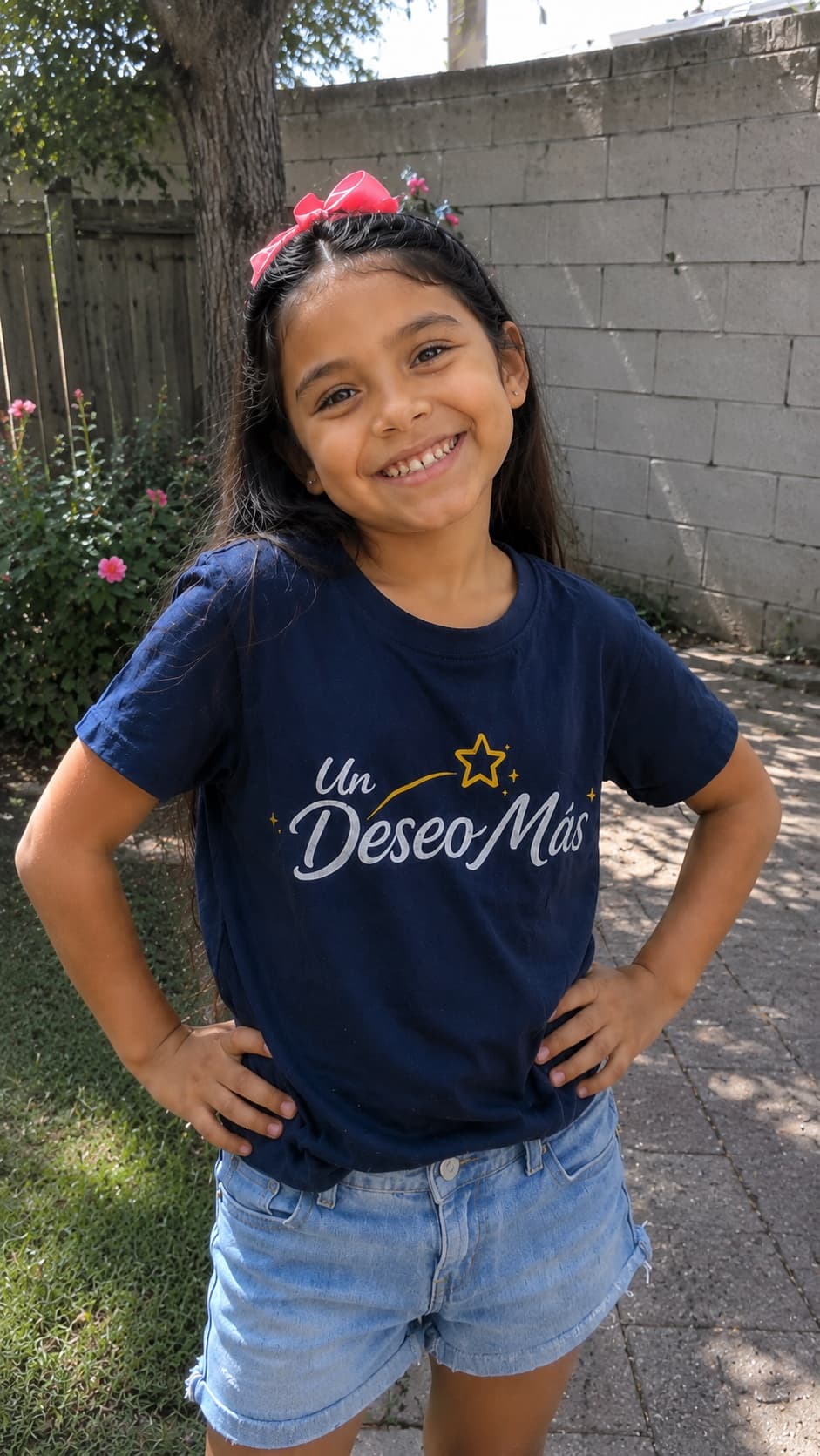 Niña de Un Deseo Más sonriendo con la camiseta de la organización
